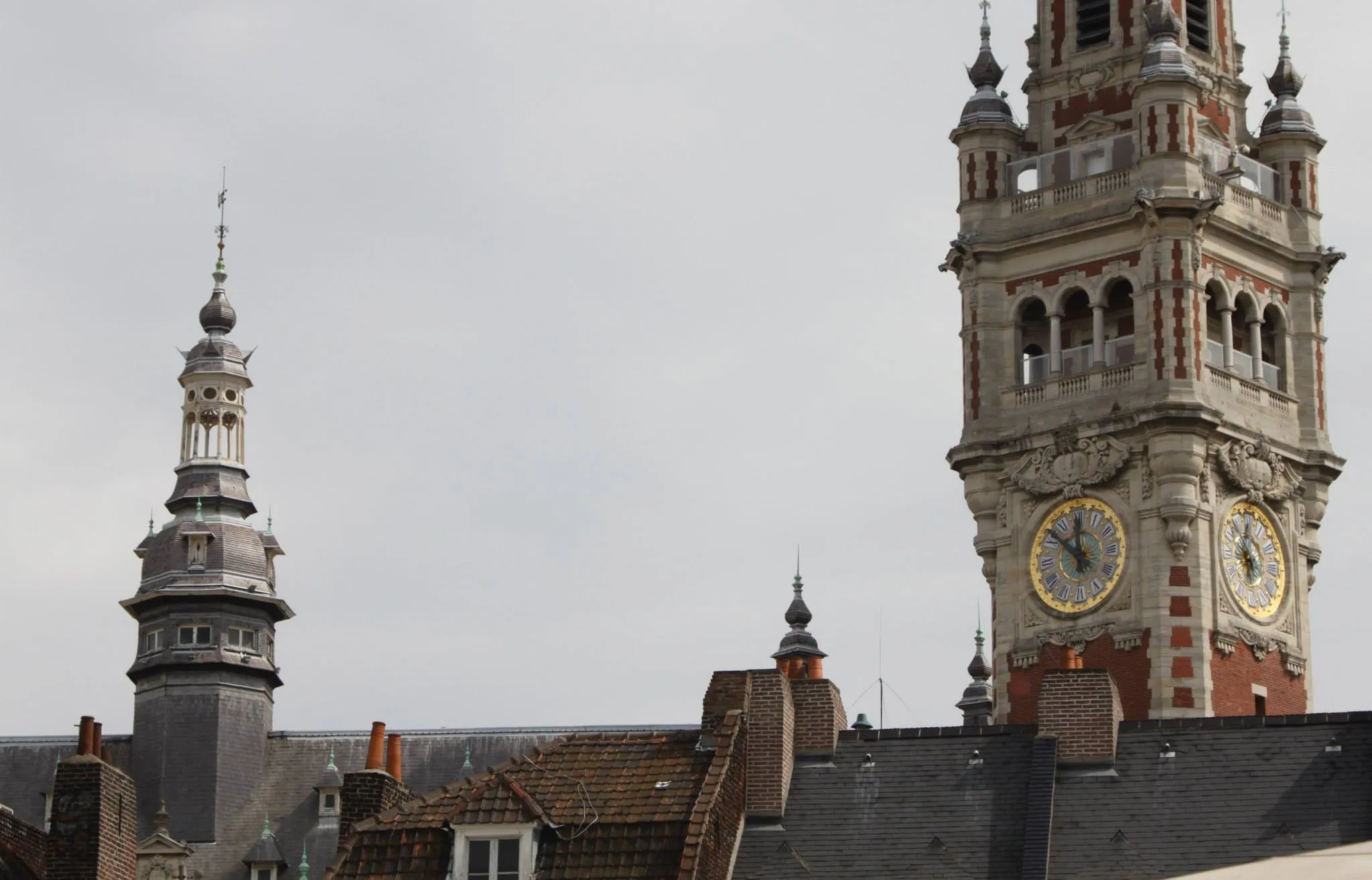 The clock tower of L'Hôtel de Ville looms over the rooftops in Lille.