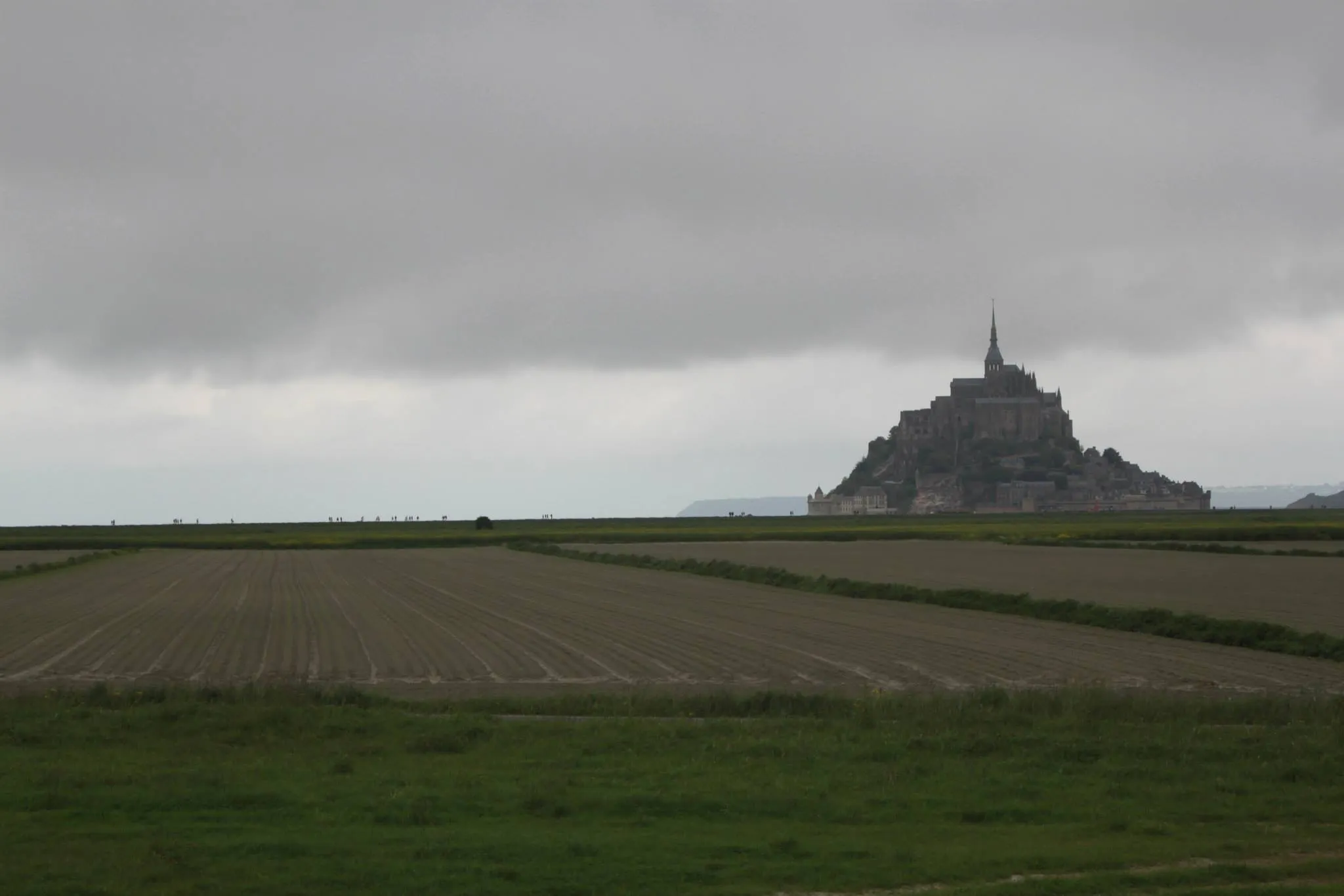 Mont St. Michel in the landscape on an overcast day.